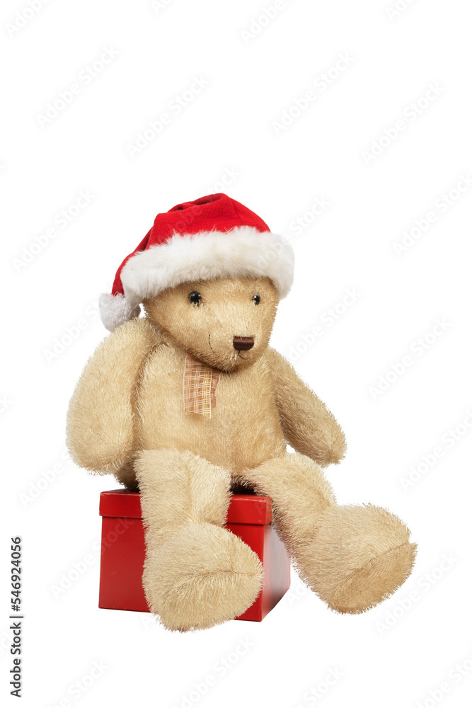 Ours en peluche avec bonnet de Noël assis sur une boîte cadeau rouge
