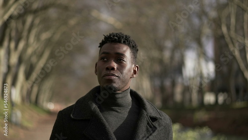 Contemplative young black African man walking outside