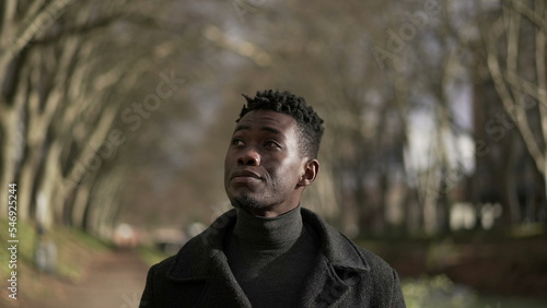 Contemplative young black African man walking outside