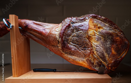 Dry-cured spanish ham. Jamon on a wooden stand.