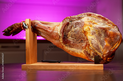 Dry-cured spanish ham. Jamon on a wooden stand.