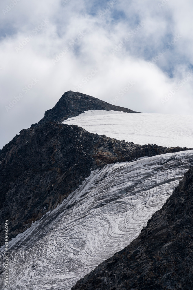 Alpine scene. Ice and snow high in the Alps. Walking the Peiljoch (2676m) Trail. Hiking in