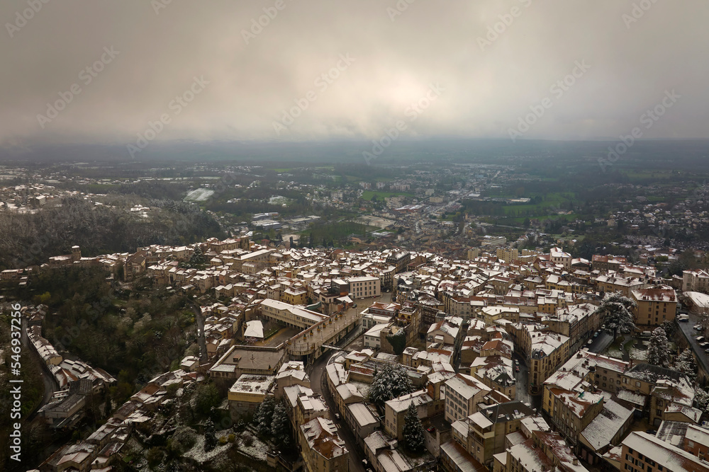 Obraz premium Aerial winter landscape of dense historic center of Thiers town in Puy-de-Dome department, Auvergne-Rhone-Alpes region in France. Rooftops of old buildings and narrow streets at snowfall