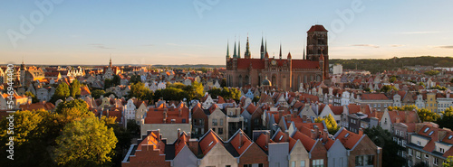 Beautiful architecture of old town in Gdansk, Poland at sunny day. Panorama banner size Aerial view from drone of the Main Town Hall and St. Mary Basilica. City Architecture from Above. Europe Tourist