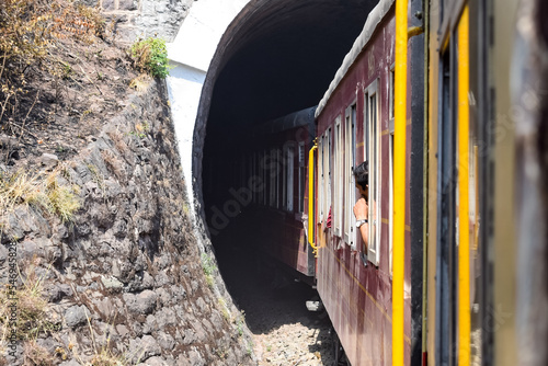 Toy Train moving on mountain slopes, beautiful view, one side mountain, one side valley moving on railway to the hill, among green natural forest. Toy train from Kalka to Shimla in India, Indian Train photo