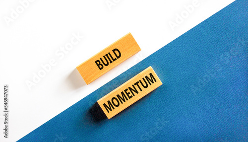 Build momentum symbol. Concept words Build momentum on wooden blocks. Beautiful white and blue background. Business and build momentum concept. Copy space.