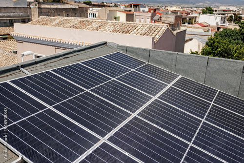 pannello fotovoltaico posizionato sul tetto di una casa in contesto cittadino  photo