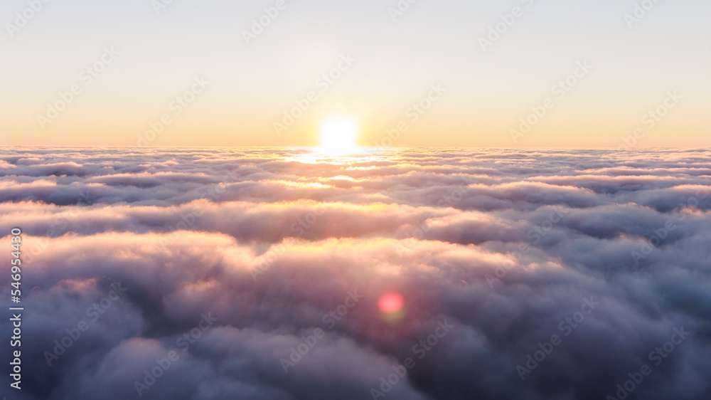 Sunset over waves of heavy thick fog. Dark clouds of fog. The sun shines over heavy purple hazy clouds at high altitude: evening sunset above the clouds. - obrazy, fototapety, plakaty 