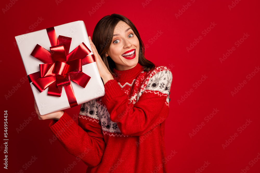 Portrait of good mood gorgeous cute thankful woman bob hairdo dressed red sweater impressed hold gift isolated on red color background Portrait of good mood gorgeous cute thankful woman bob hairdo dressed red sweater impressed hold gift isolated on red color background