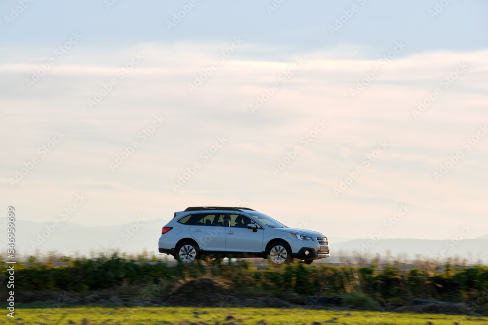 SUV car driving fast on intercity road at sunset. Highway traffic in evening SUV car driving fast on intercity road at sunset. Highway traffic in evening