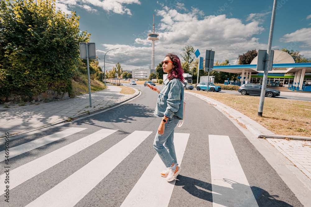 The girl crosses the road at the zebra crossing. Rules and pedestrian