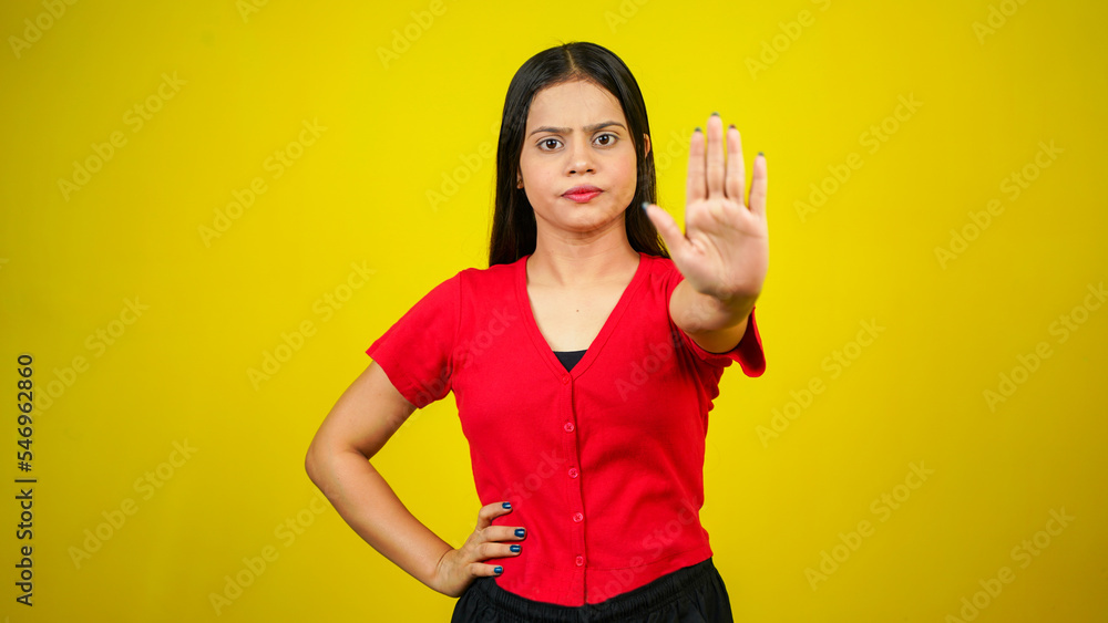 Portrait of a Asian beautiful young woman unhappy or confident standing say no, studio shot isolated yellow background, Indian female pose saying reject gesture with copy space Portrait of a Asian beautiful young woman unhappy or confident standing say no, studio shot isolated yellow background, Indian female pose saying reject gesture with copy space