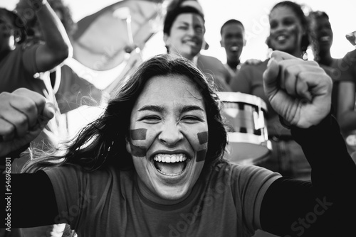 Sport football fans celebrating team victory in championship game at stadium - Soccer supporters having fun in crowd - Black and white editing photo