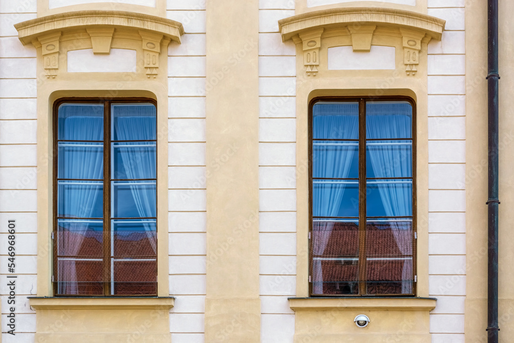 Two rectangular windows with a visor on the background of a yellow wall. From the Windows of the world series.