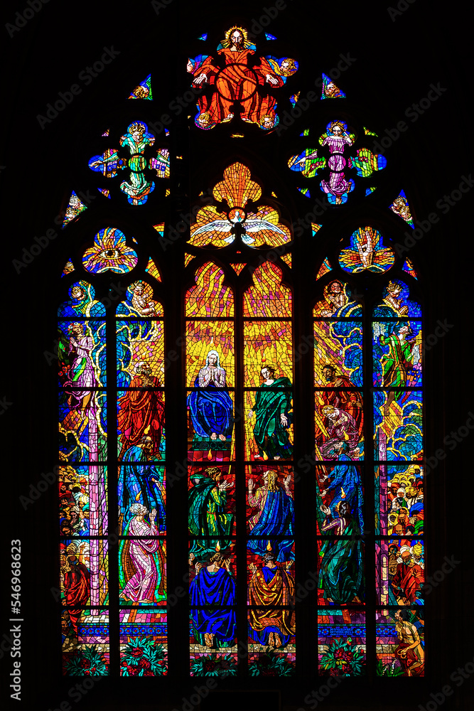 Arched window with stained glass stained glass on religious themes on a dark background.