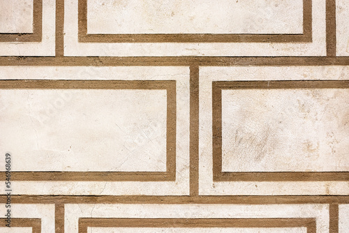 Fragment of a beige wall with a pattern in the form of brown stripes for use as an abstract background and texture.