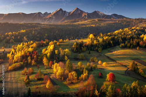 Fototapeta Naklejka Na Ścianę i Meble -  Autumn views near the village of Osturnia in Slovakia. Colorful trees harmonize beautifully with the Tatra Mountains in the background.