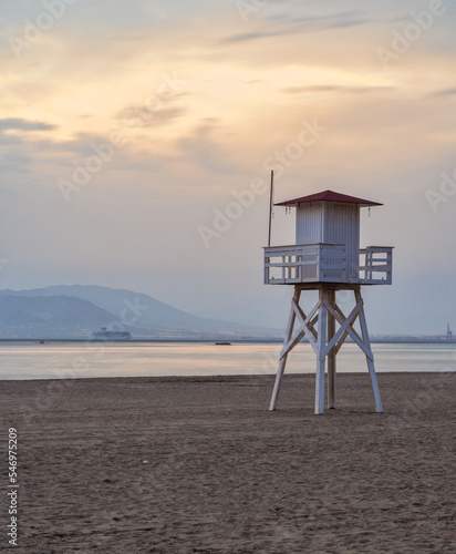 View at sunset on the deserted beach with the wooden lifeguard tower.