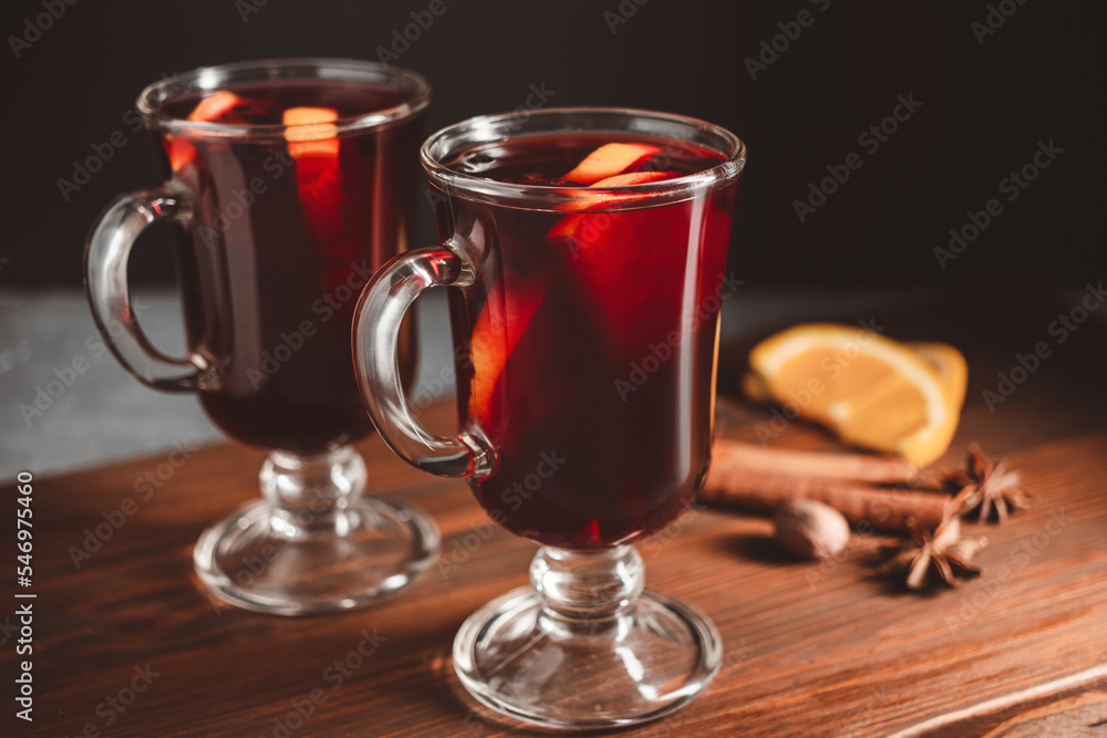 Mulled red wine in a glass and spices on wooden background Mulled red wine in a glass and spices on wooden background