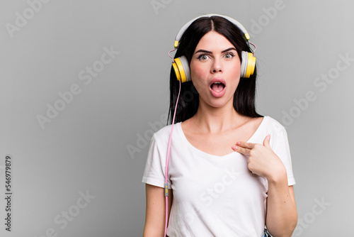 looking shocked and surprised with mouth wide open, pointing to self. listening music qith a headphones photo