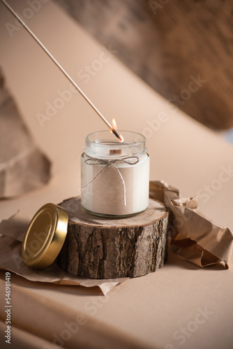 Selective focus Soy candle in a glass jar with a wooden lid. Aromatherapy. Candle on a beige background closeup. Place for a label. Wax and wick. Home decor. Handmade. Air freshener. Soy candle