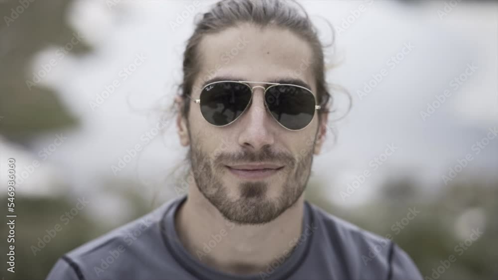 Man with beard and sunglasses smiling in front of the snow Man with beard and sunglasses smiling in front of the snow