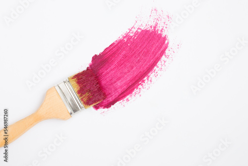 Paintbrush with pink pomade on the white background. Top view. Copy space.