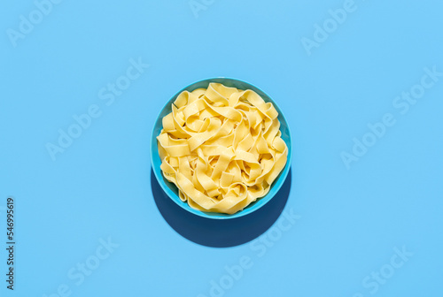 Pappardelle pasta bowl isolated on a blue background photo