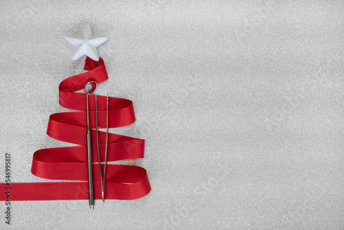 Zahnärztlicher Weihnachtshintergrund mit Platzhalter. Grundbesteck aus der Zahnarztpraxis, Spiegel, Sonde, Pinzette in einer weihnachtlichen Schleife verpackt