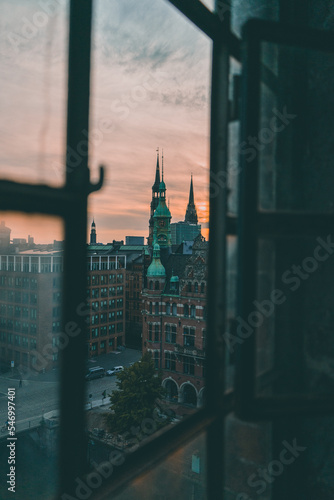 This picture shows the view from an old window in the Hamburg Hafencity during sunset. © Alicia