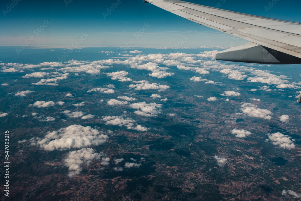 Aerial view of a land mountain landscape while flying away with a passenger aircraft scenic view from the window plane Aerial view of a land mountain landscape while flying away with a passenger aircraft scenic view from the window plane