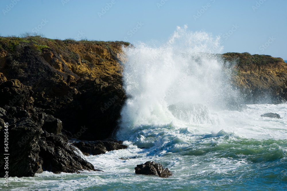 Ocean waves break against rocky outcrops along the Central Coast of California.