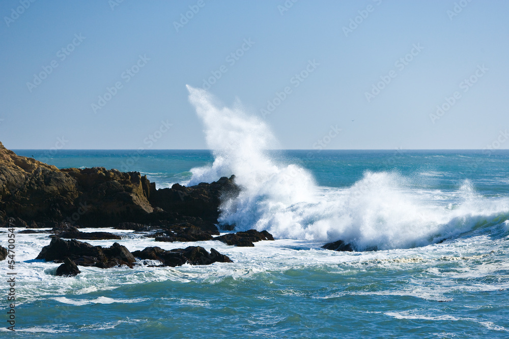 Ocean waves break against rocky outcrops along the Central Coast of California