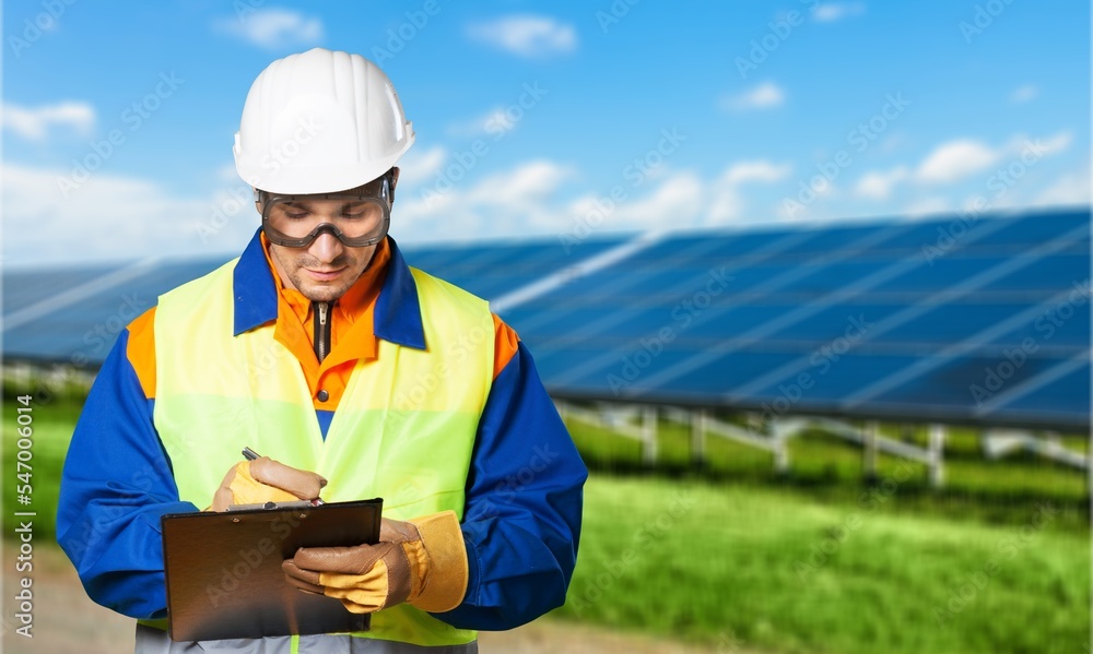 Fototapeta premium Young engineer worker inspecting a solar panel