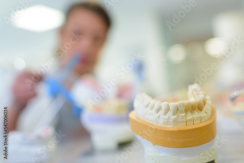 dental technician is working with a dental denture