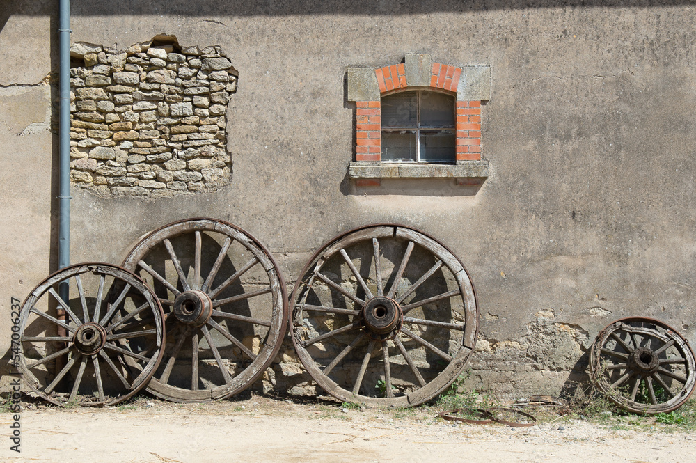 Four old wooden wheels with metal strapping, designed for hay and straw
