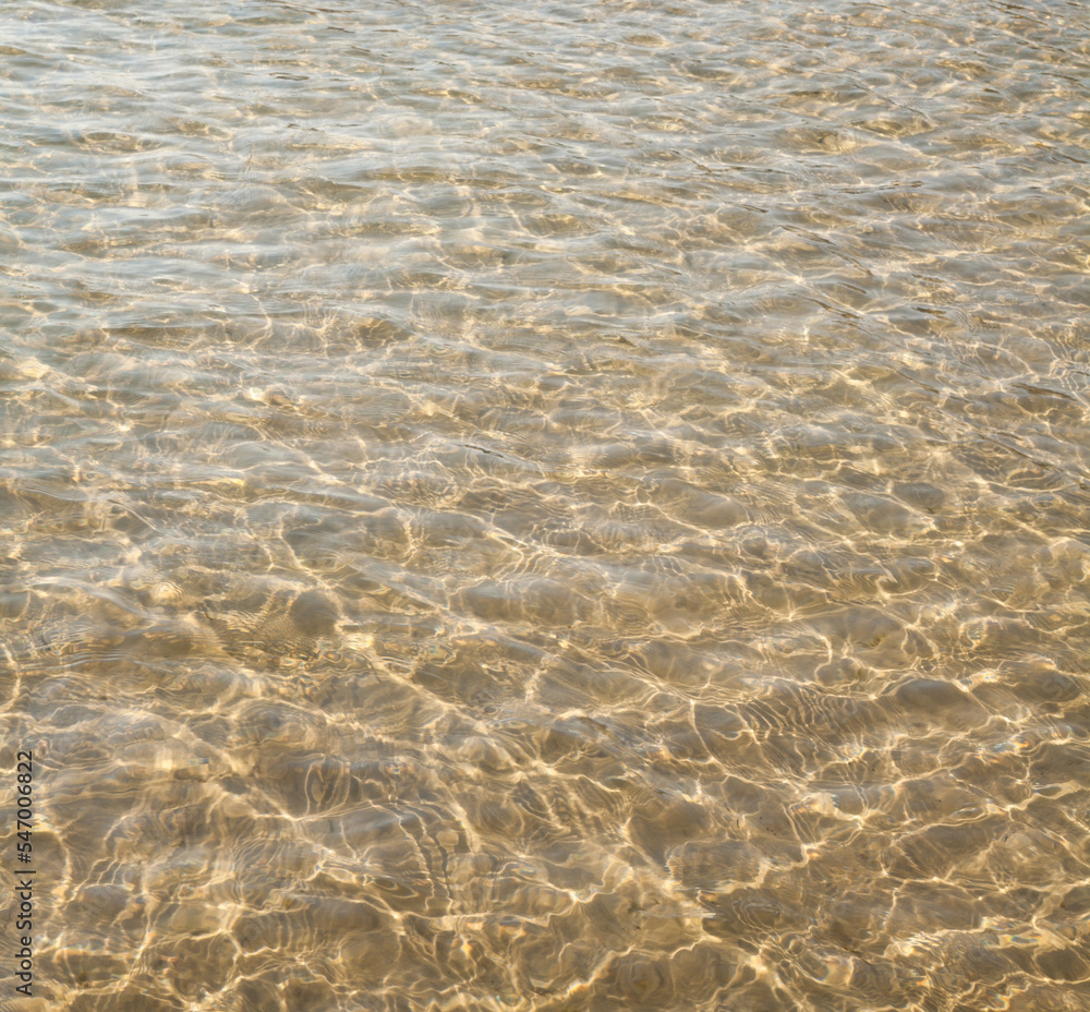 Water surface with ripples and sunrays reflections Water surface with ripples and sunrays reflections