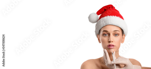Young woman in Santa hat re...