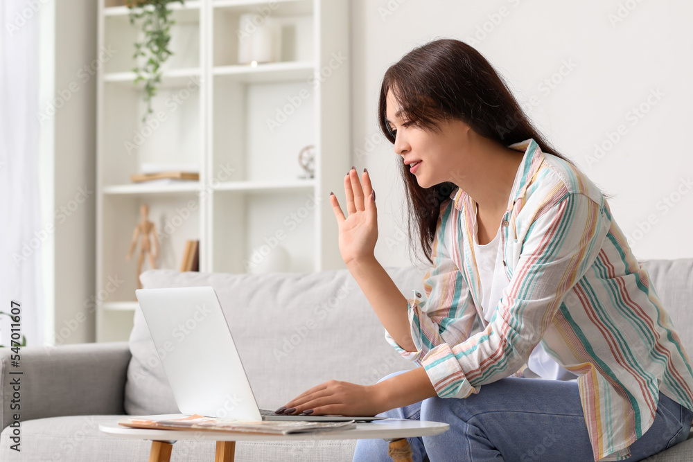 Young Asian woman video chatting with laptop at home Young Asian woman video chatting with laptop at home