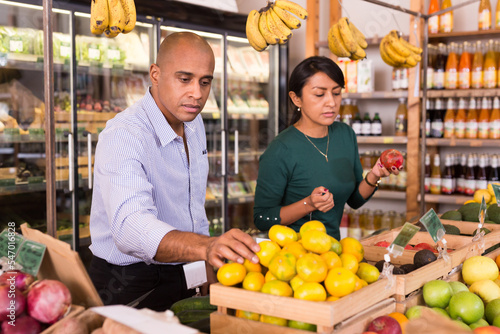 Male consumer choosing ripe tangerines in supermarket © JackF