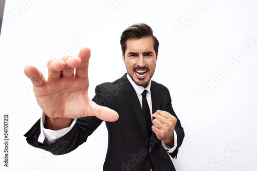 Portrait of a man in an expensive business suit close-up wide-angle lens pulling his hands into the camera with his mouth open screams against a white background, copy location