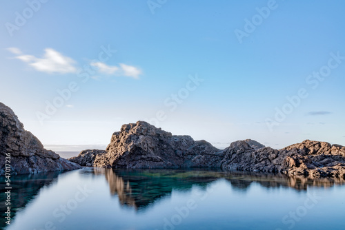 Landscape with a natural pool formed by volcanic rock next to the sea