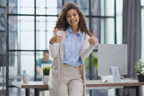 Proud office worker posing with thumbs up