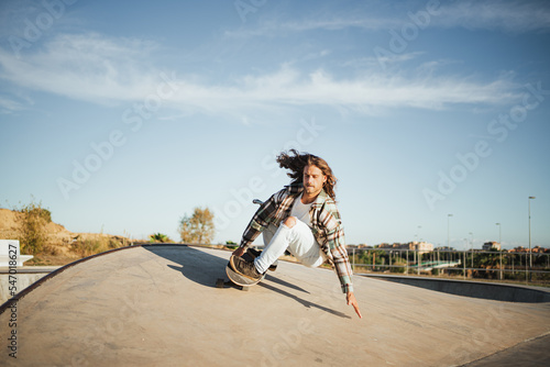Skater drifting on a ramp. He is at a skate park practicing surfskating