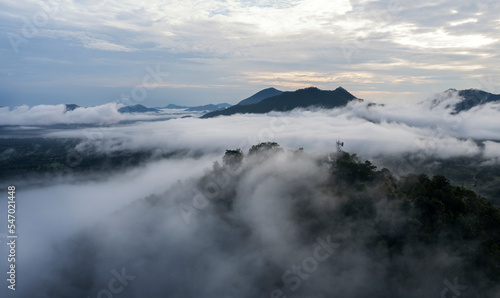 Aerial view drone fly over Sea of fog, Floating sea of clouds like cloud waves on mountains, Sky and clouds. View on the mountain full of fog in the morning at Phu Tok, Loei Province. Thailand