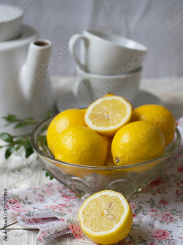 lemons in glass plate and white tea set. lemons whole and halves. Provence. Closeup.