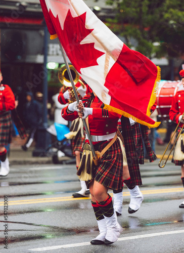 A girl carrying a Canadian flag on a parade