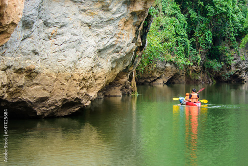 Pha Hob mountain, beautiful natural rock mountain and forest on side of river. Children are kayaking on the river