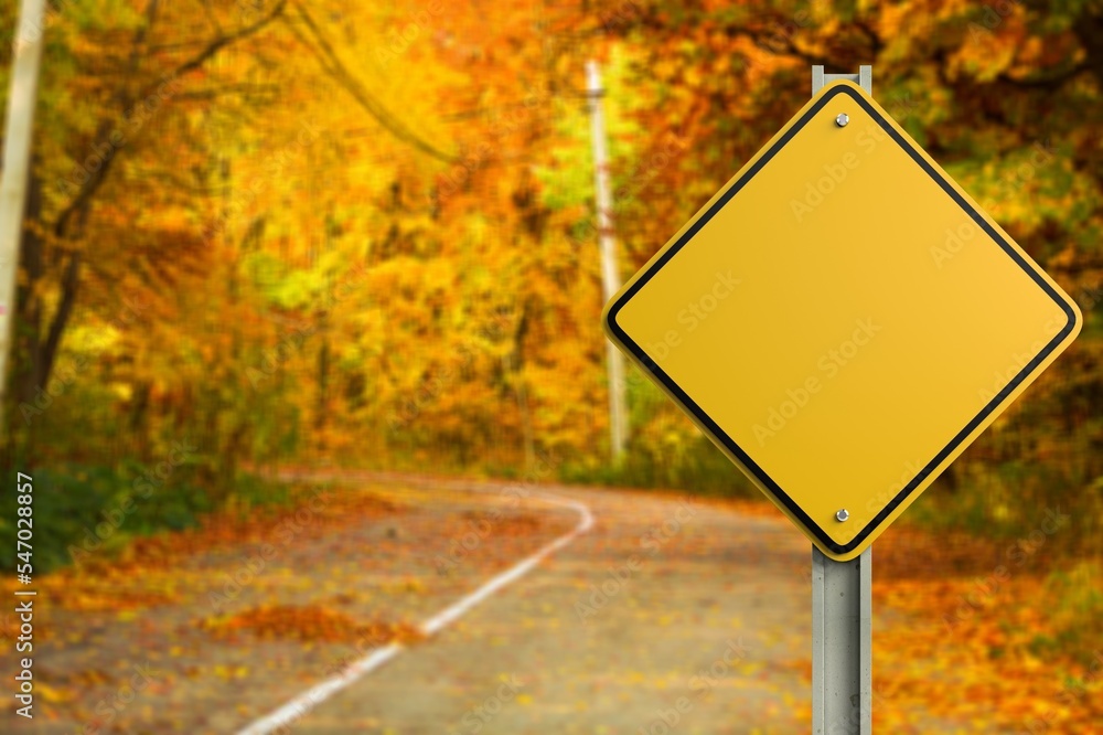 Big yellow road sign at autumn background