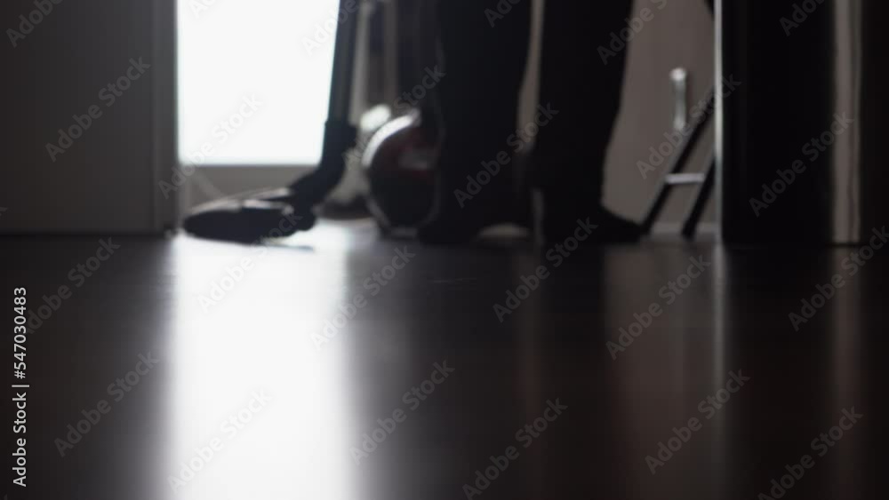 Defocused background low angle view of person vacuuming laminate floor Defocused background low angle view of person vacuuming laminate floor